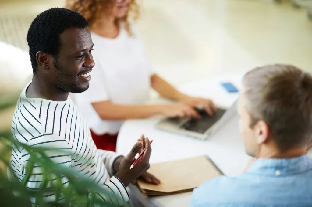 Small business team collaborating around a laptop during a meeting