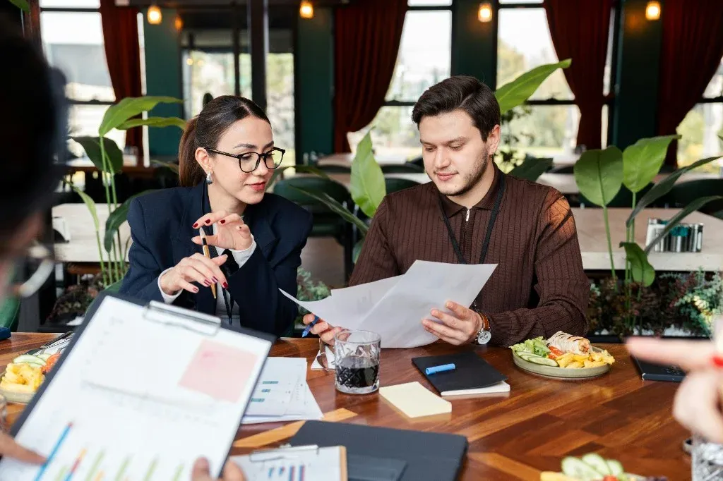 Team reviewing charts and graphs spread across a meeting table
