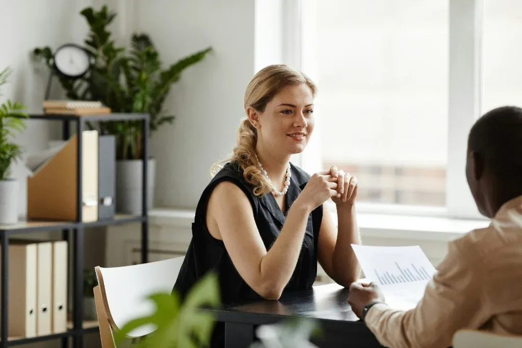Two colleagues reviewing documents together in a bright office