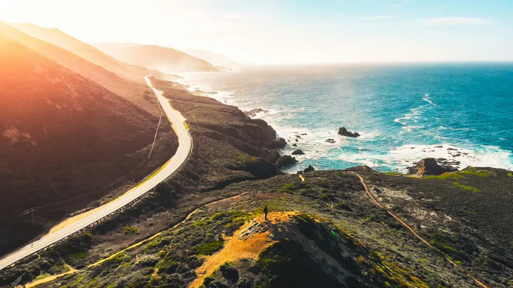 Coastal highway winding along the Pacific cliffs of Big Sur, California at golden hour
