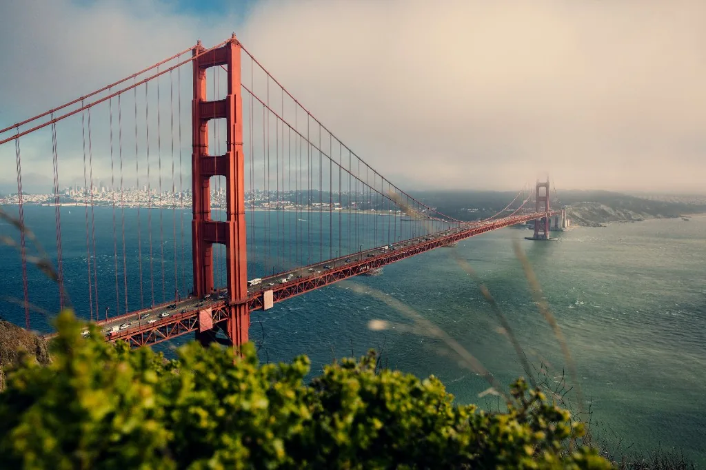 Golden Gate Bridge spanning San Francisco Bay with fog rolling in from the Pacific